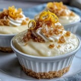 Zesty lemon mousse cups with buttery shortbread crumble, a refreshing spring dessert in elegant glasses.
