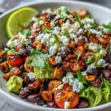 Vibrant grilled corn kernels and black beans tossed with fresh vegetables and crunchy tortilla chips in a taco salad.  