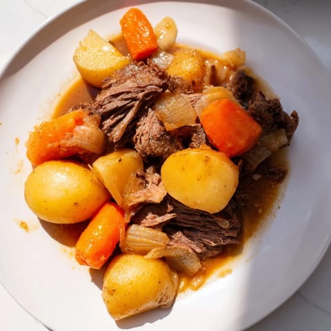 This close-up shows steaming Beef Pot Roast, a classic American comfort food meal.