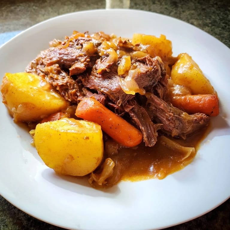 A generous serving of Beef Pot Roast, with vegetables and flavorful juices, ready to enjoy.