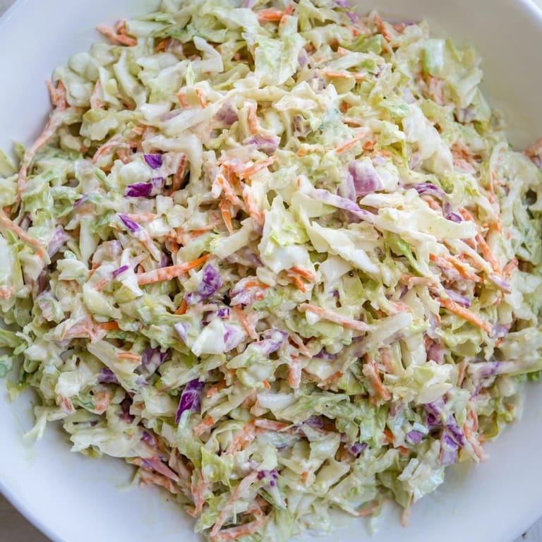 Cool, crunchy coleslaw, ready to enjoy as a perfect side dish on a summer picnic spread.