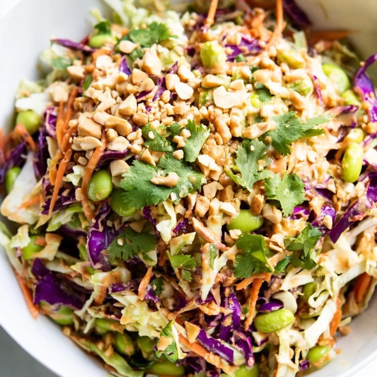 Freshly chopped cilantro and roasted peanuts garnish this Crunchy Thai Peanut Salad, perfect for a refreshing light lunch or side.