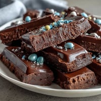 Festive pastel chocolate bark with Cadbury eggs, swirls of colorful candy melts, and sprinkles on a serving tray.